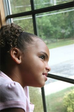 Child looking through sash window 